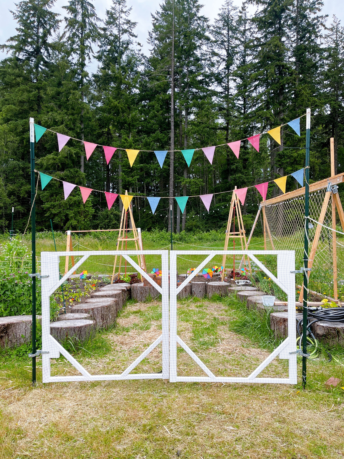 an open garden gate with bunting hanging from it